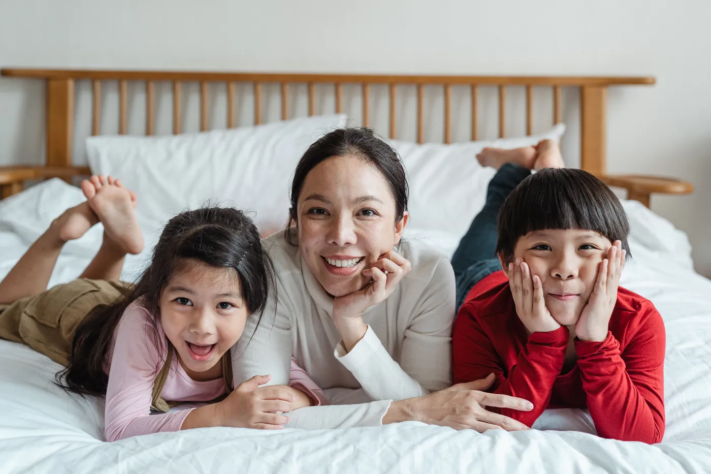 Mother smiling with two children on a bed